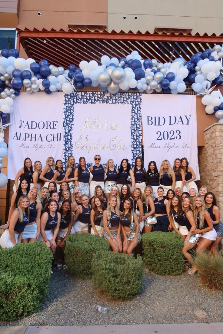 a group of women posing for a photo in front of a sign that says bid day