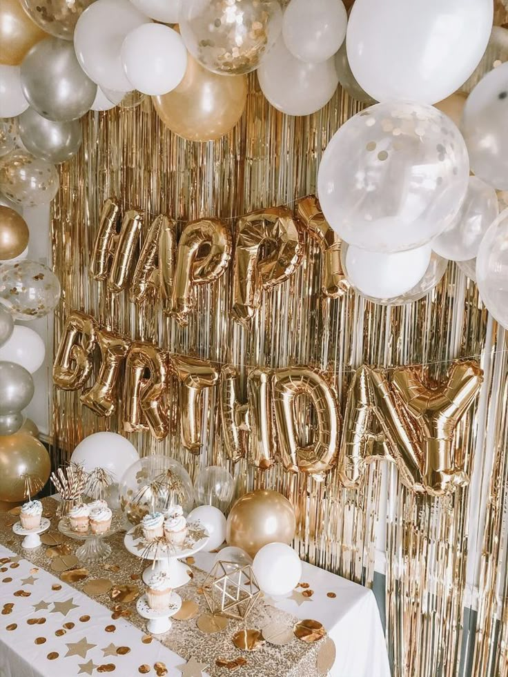 a table topped with gold and white balloons