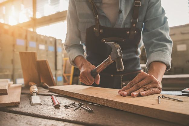 a man working with tools on a wooden table