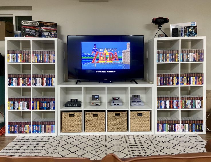 a flat screen tv sitting on top of a white book shelf