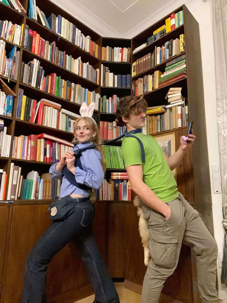 two people standing in front of a bookshelf