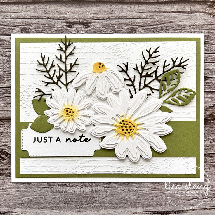 a card with white flowers and green leaves on it, that says just a note