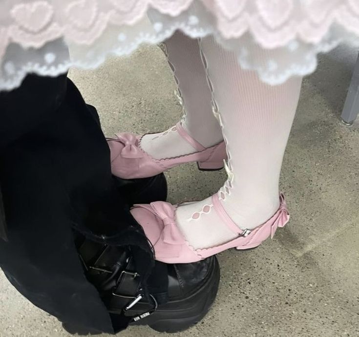 two pairs of shoes sitting on top of each other in front of a person's legs