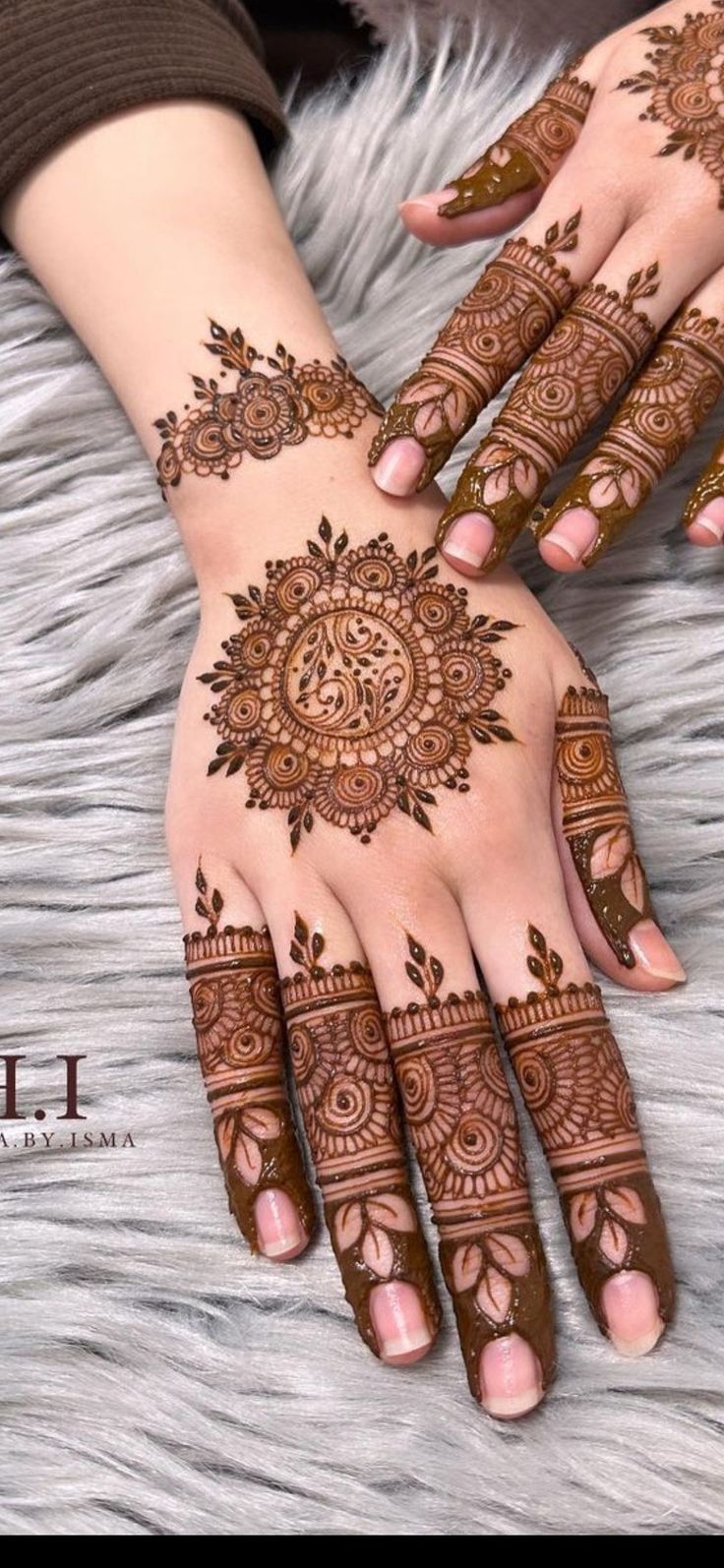 two hands with henna tattoos on them