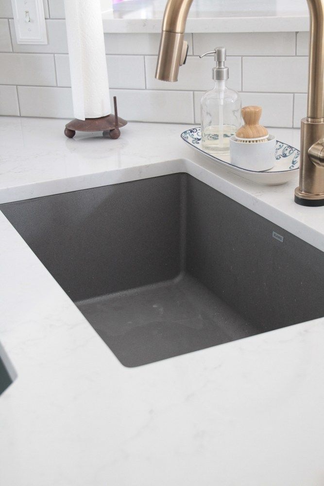 a kitchen sink with a faucet and soap dispenser