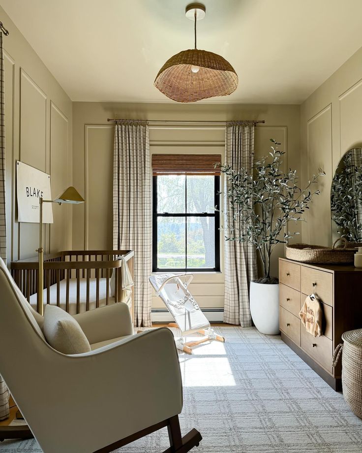 a living room filled with furniture and a baby crib next to a large window