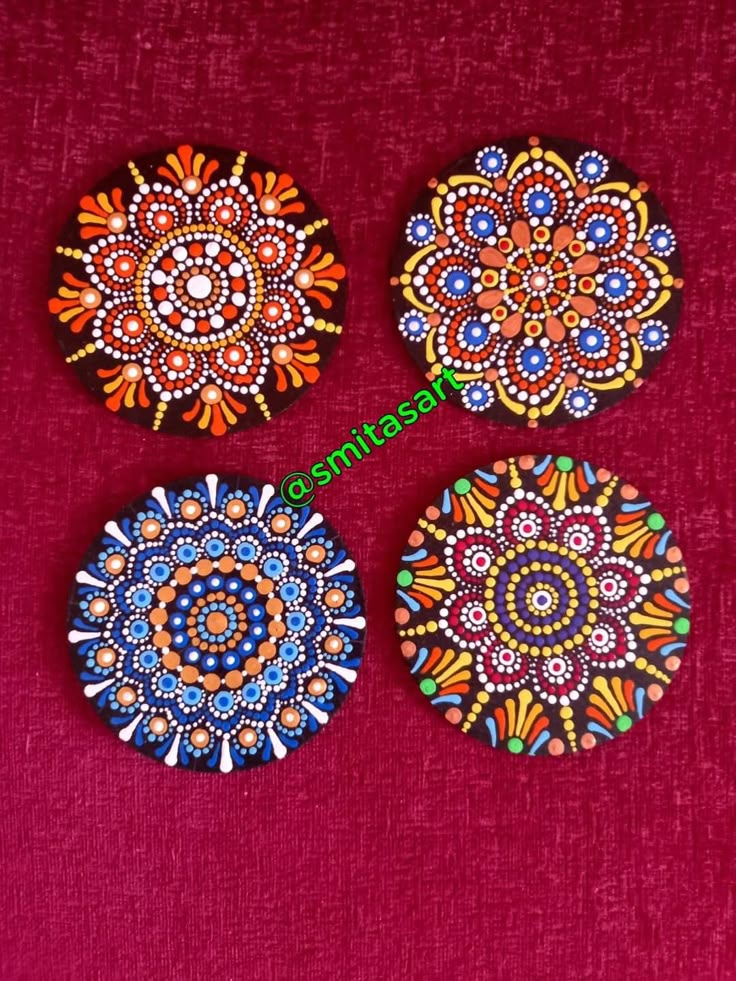 three colorful painted plates sitting on top of a red cloth