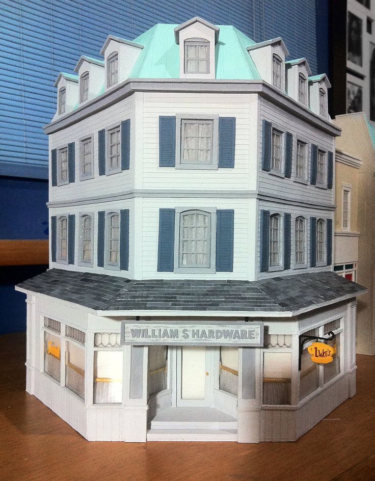 a paper model of a white building with blue shutters on the front and windows