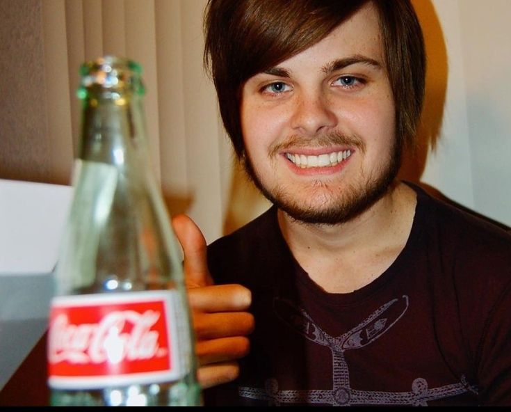 a man is giving the thumbs up while holding a bottle of coca - cola in his hand