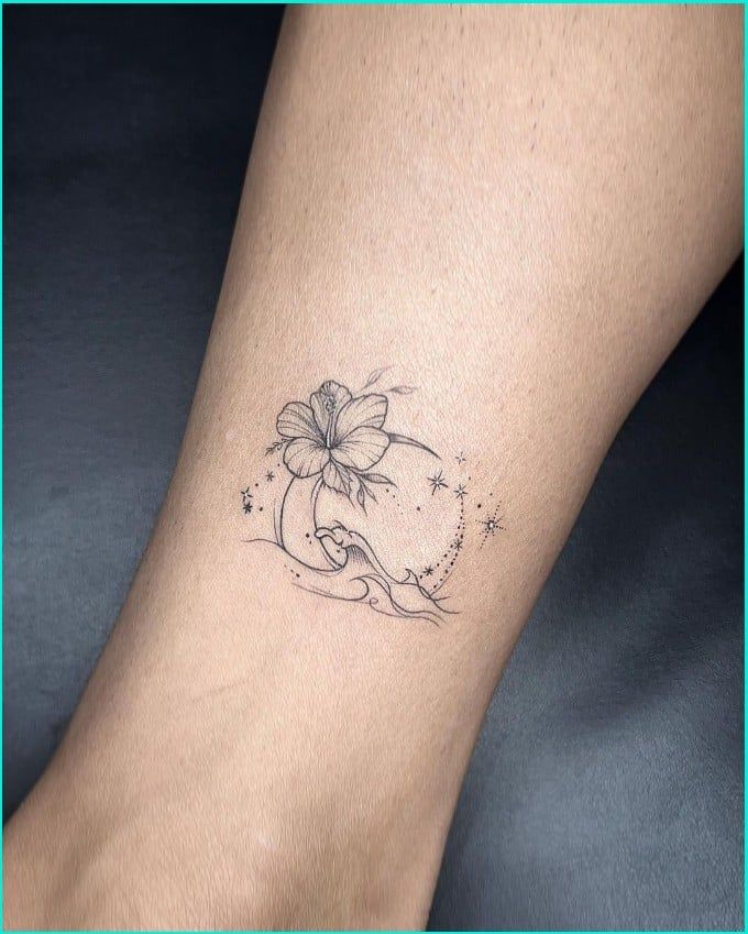 a woman's foot with a flower tattoo on the left side of her leg