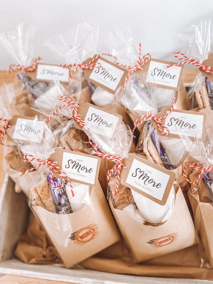 some cookies wrapped in brown paper with red and white twine on them are sitting in a box