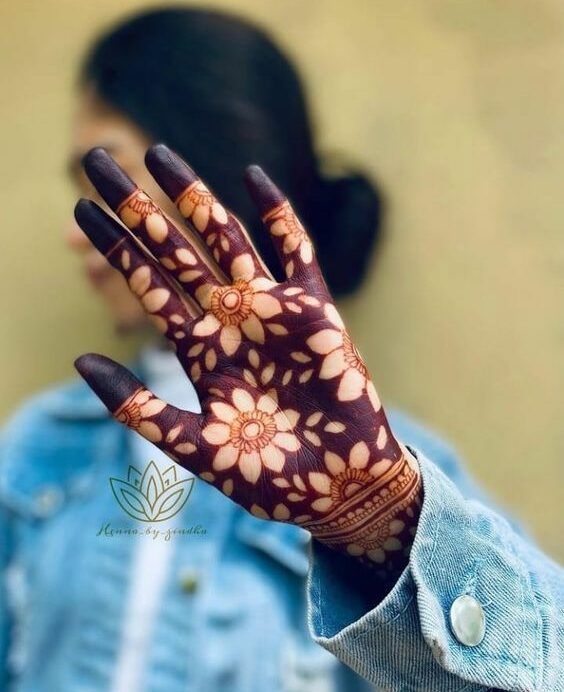 a woman's hand with hennap on it and flowers painted on the palm