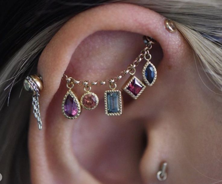 a close up of a person with ear piercings on their ears and one behind the ear