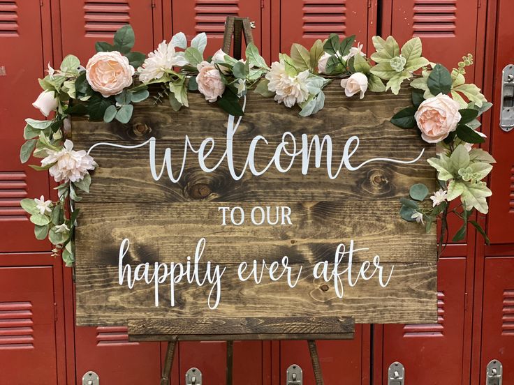 a wooden sign with flowers on it that says welcome to our happily ever after,