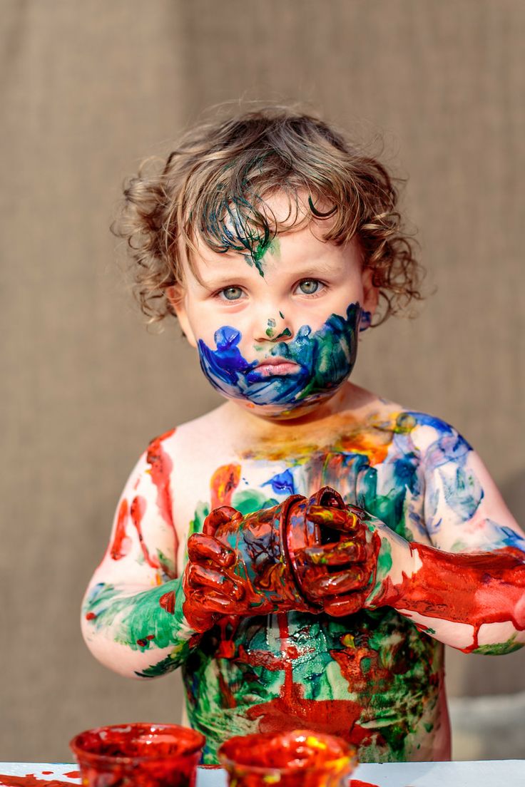 a little boy with his face painted in different colors