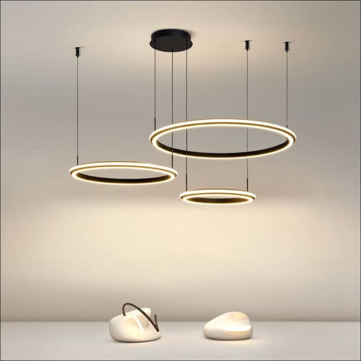 three circular lights hanging from the ceiling in a room with white walls and flooring