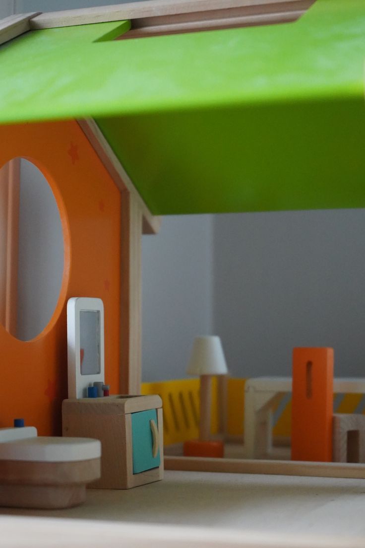 a toy house with an orange roof and green awning over it's windows