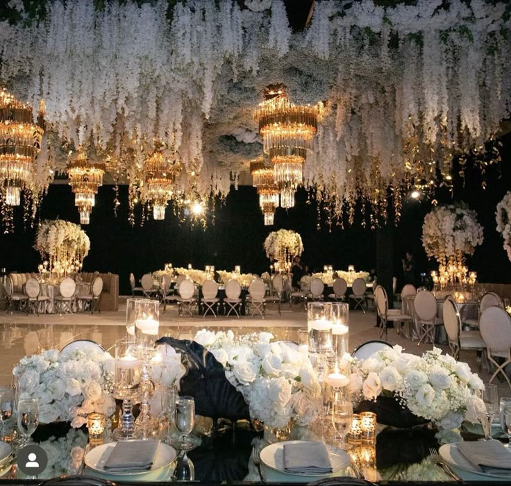 an elegant wedding setup with chandeliers and flowers