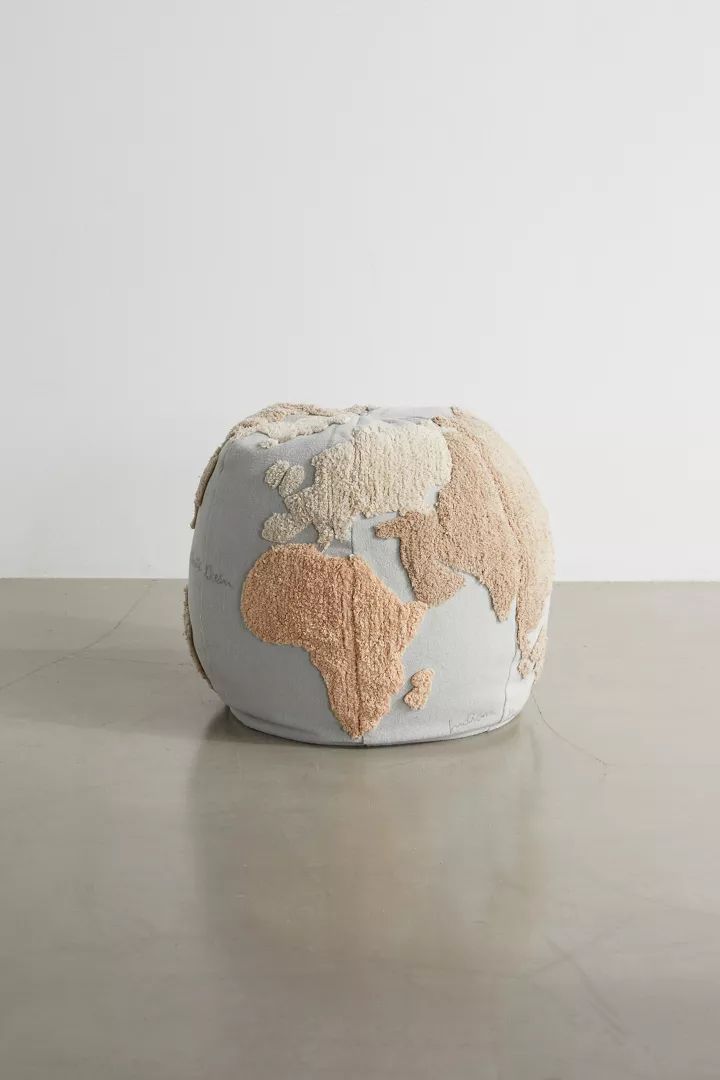 a grey and beige floor pillow with a map on the front, sitting on top of a table