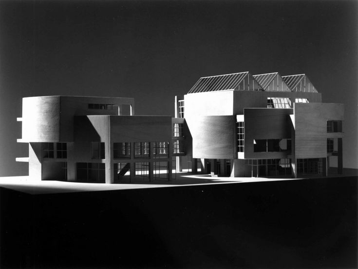 black and white photo of an architectural building with multiple levels on the roof, in front of a dark sky