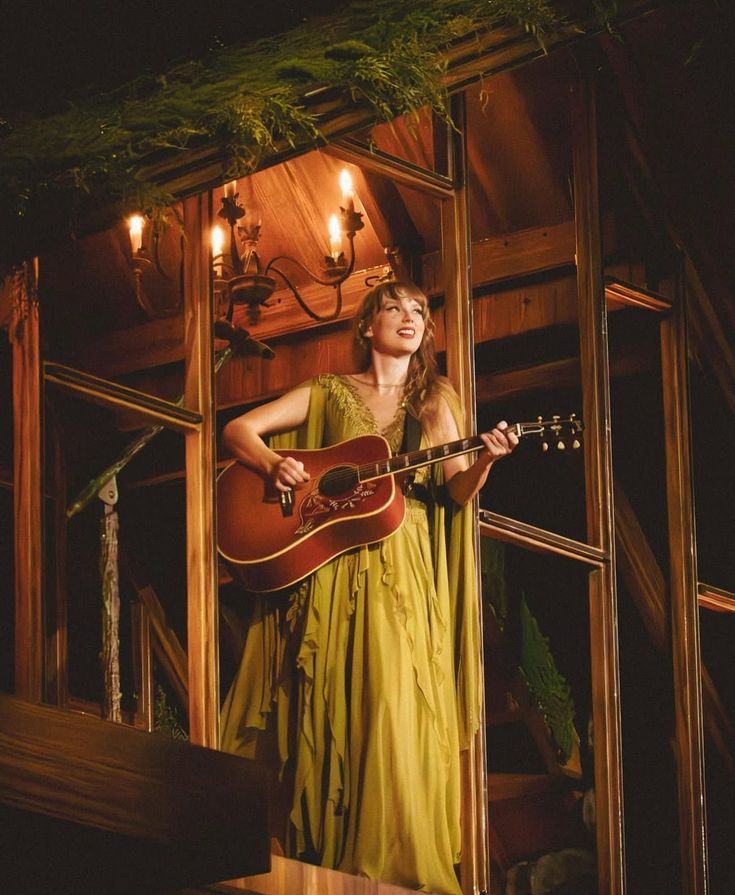 a woman in a yellow dress holding a guitar