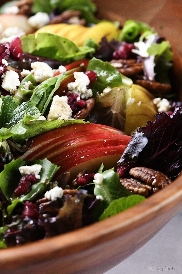 a wooden bowl filled with lots of salad