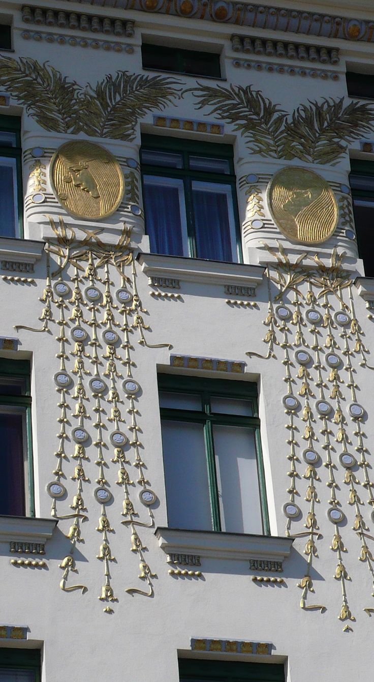 an ornate building with gold decorations on the side and windows above it's balconies