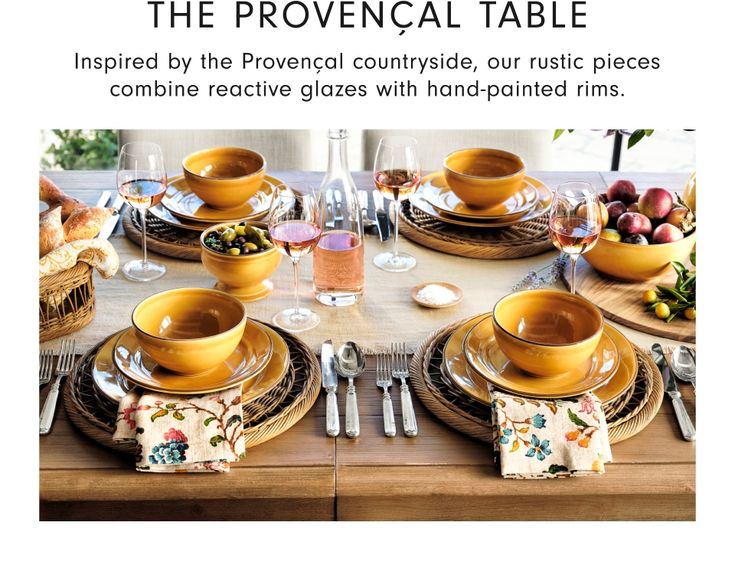 the table is set with yellow dishes and place settings for two people to sit at