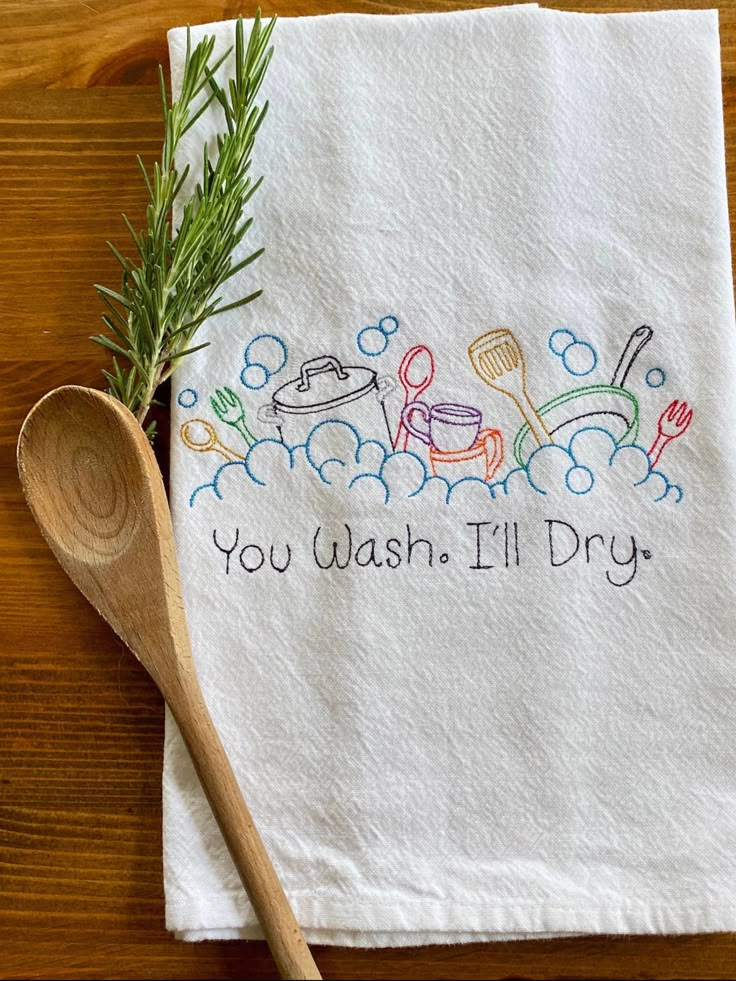 a tea towel with the words you wash i'll dry on it next to a wooden spoon