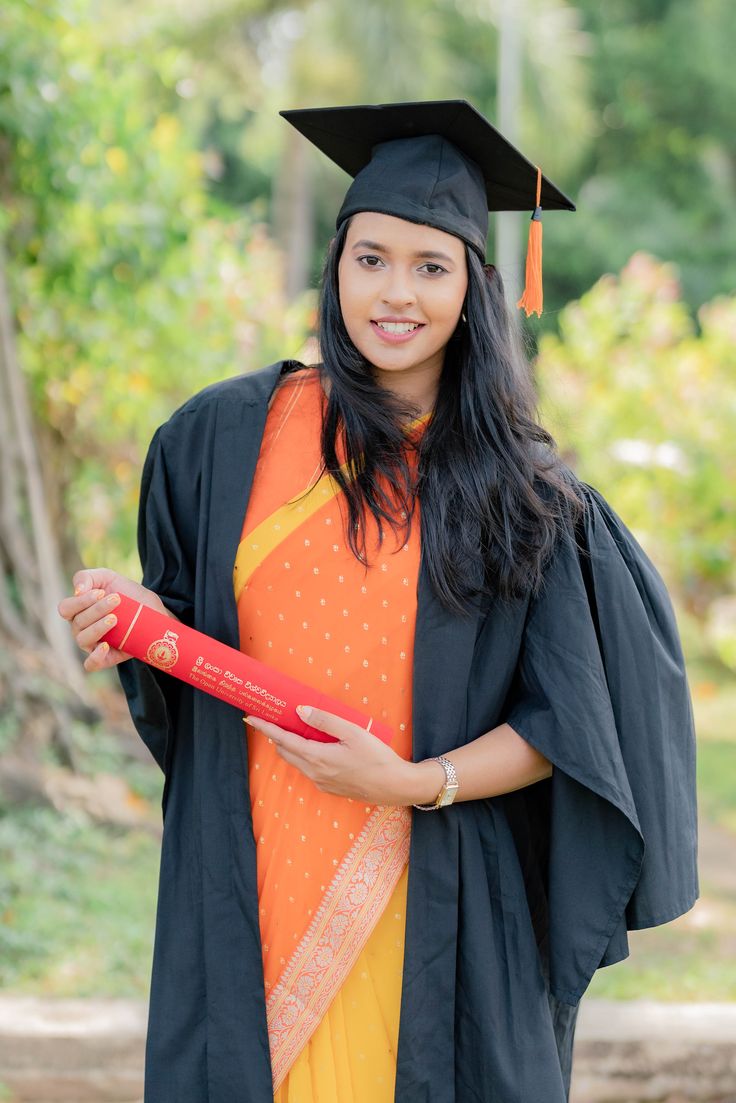 a woman in graduation gown holding a diploma