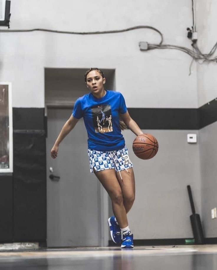 a woman dribbling a basketball on the court