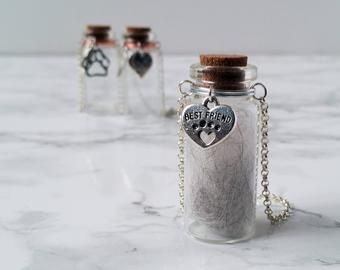 two glass bottles filled with sand on top of a marble counter next to each other