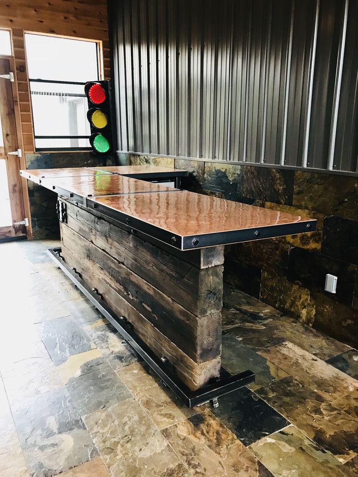 a large wooden table sitting on top of a tiled floor next to a traffic light