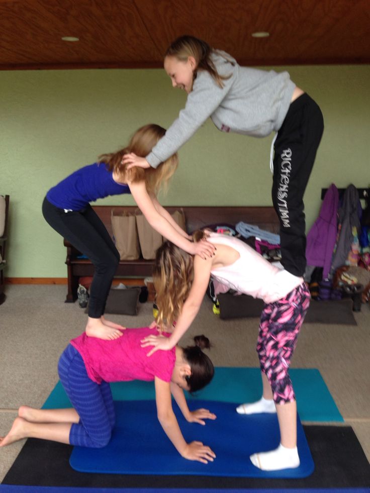 three girls are doing yoga in a room