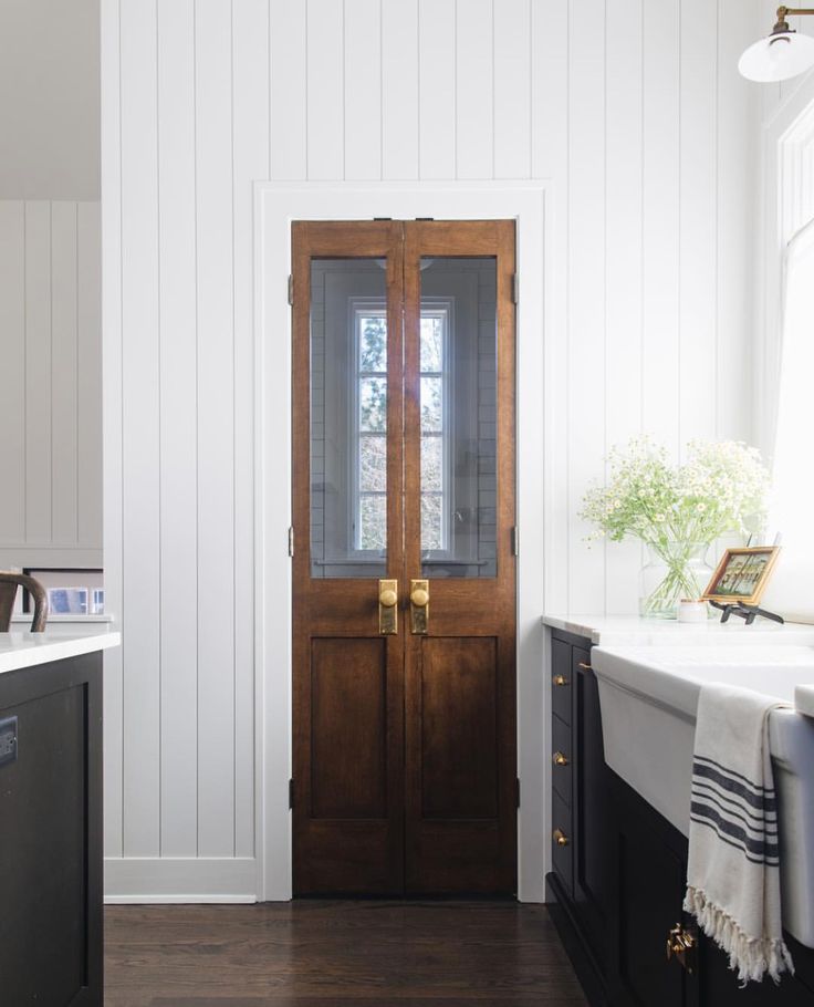 an open wooden door in a white room