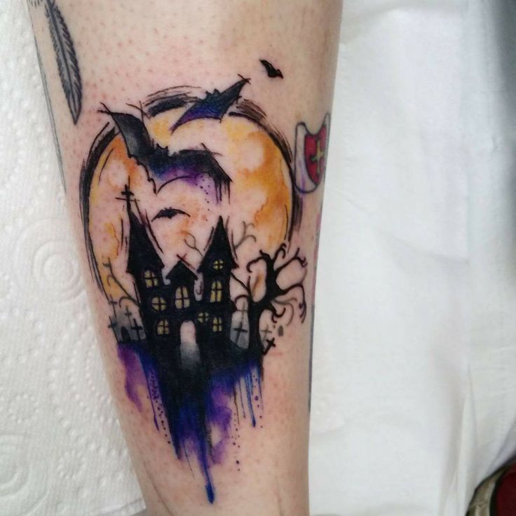 a person with a tattoo on their leg that has an image of a castle in the background