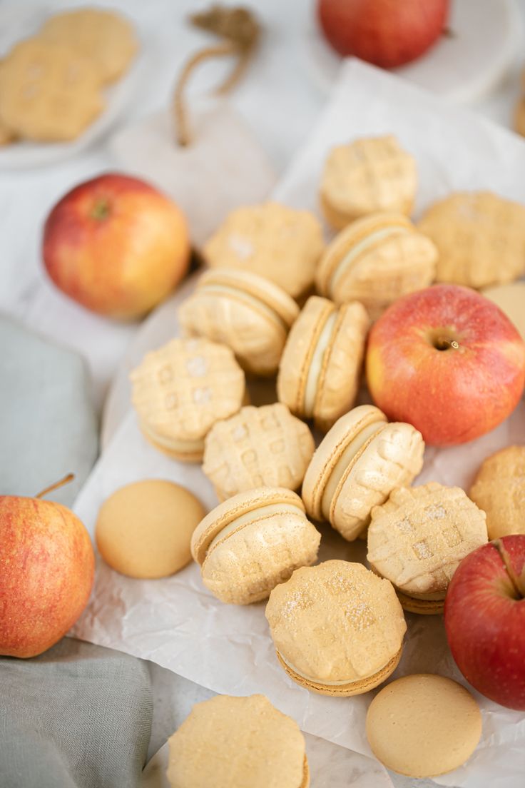 an assortment of cookies, apples and peanut butters on wax paper next to each other