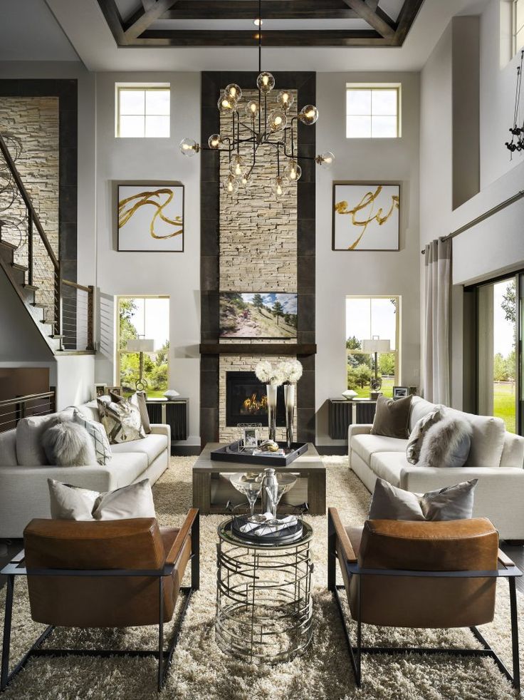 a living room with couches, chairs and a chandelier hanging from the ceiling