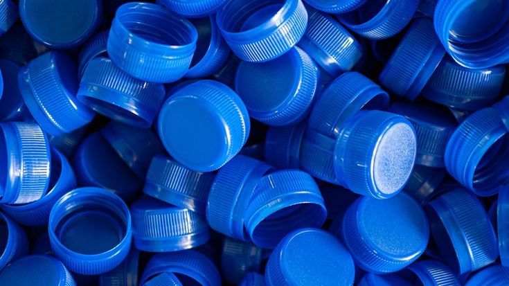 many blue plastic caps are stacked on top of each other