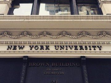 the new york university building is shown in black and white, with an ornate sign above it