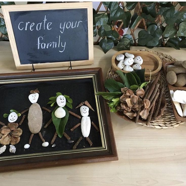 some little figurines are sitting in a shadow box on a table next to other decorations