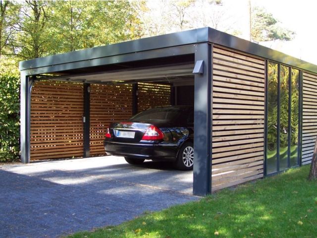 a car is parked in a carport on the side of a driveway next to a house