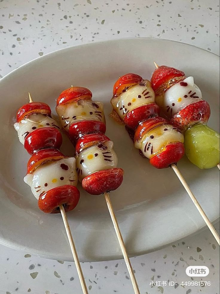 several skewered vegetables are on a white plate