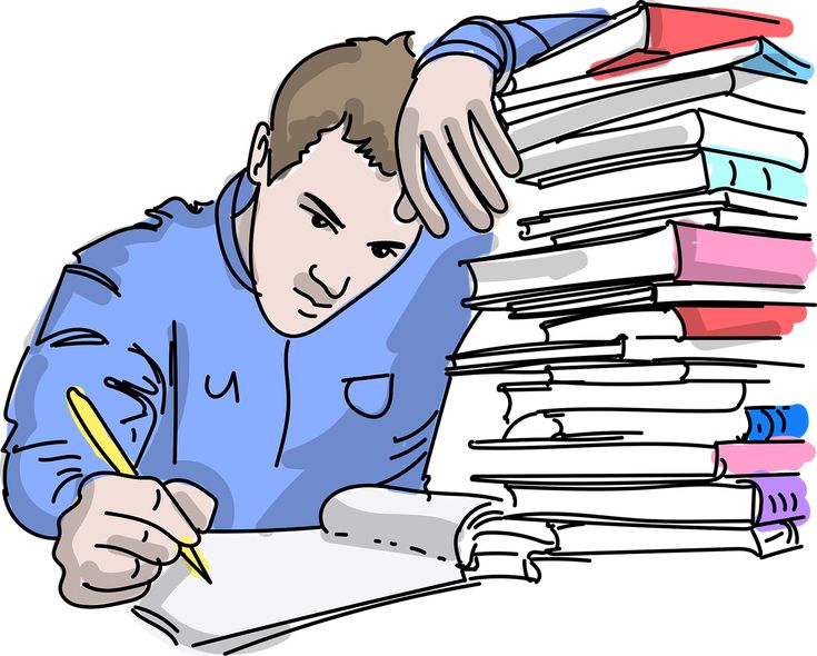 a man sitting at a table with stacks of books and writing on a piece of paper