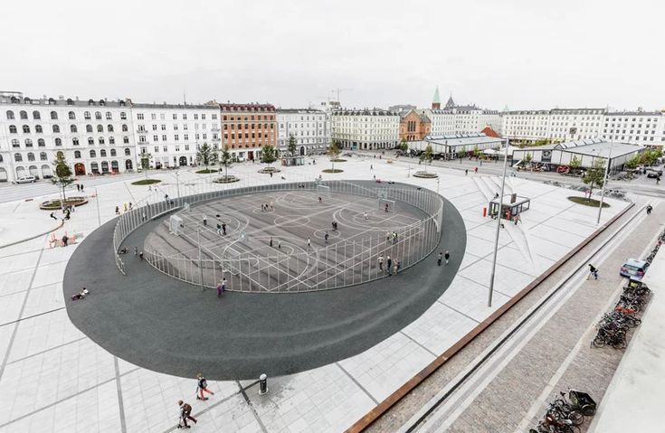 an aerial view of a city square with people walking around