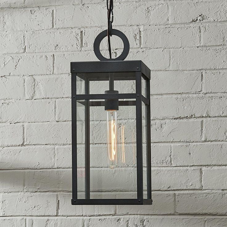 an outdoor light hanging from a brick wall