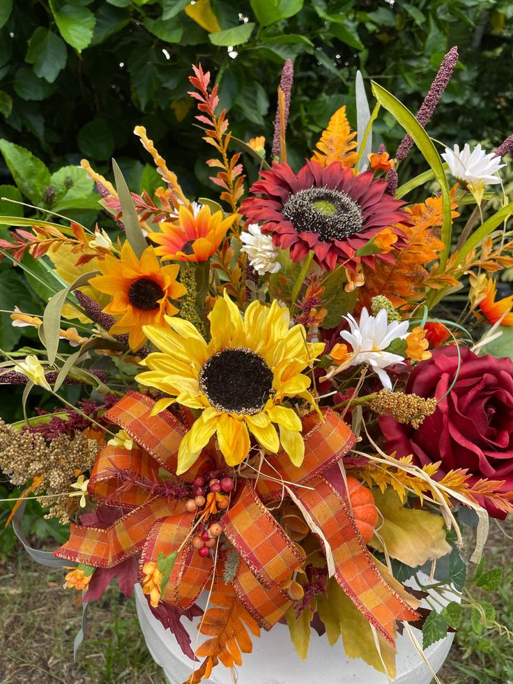 a vase filled with lots of different colored flowers