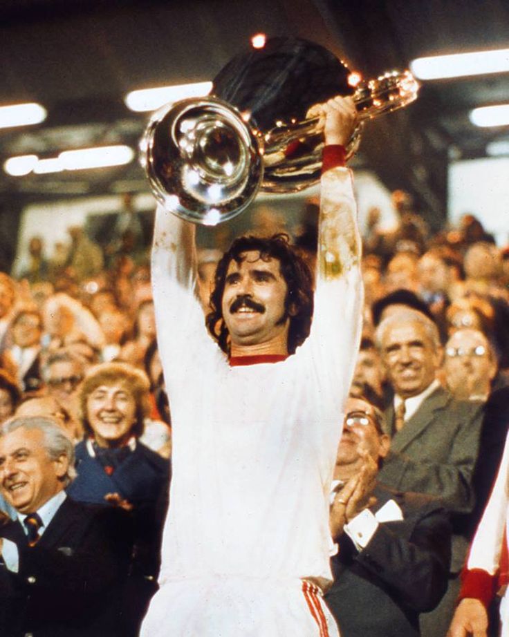 a man holding up a trophy in front of a crowd