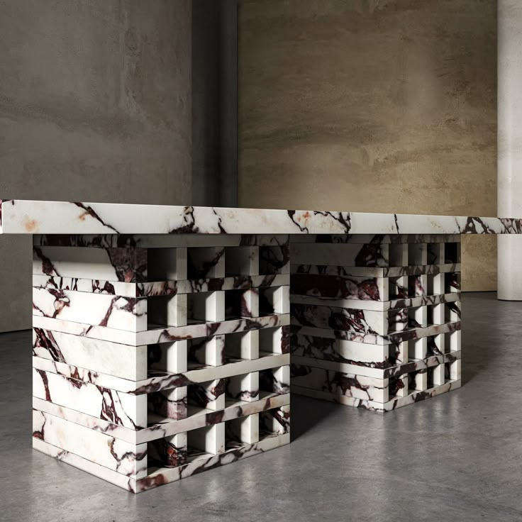 two marble tables sitting next to each other on top of a cement floor in front of a wall