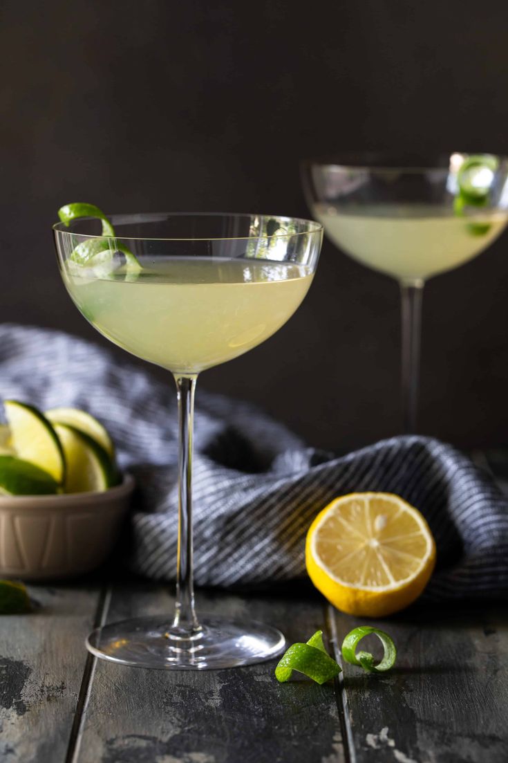 two glasses filled with lemonade and garnished with limes